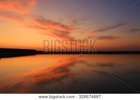 Nice evenig scene with red clouds in sky over lake