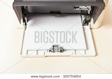 Sheets Of Blank White Paper In Printer Tray Of Multi Function Device On Table In Office