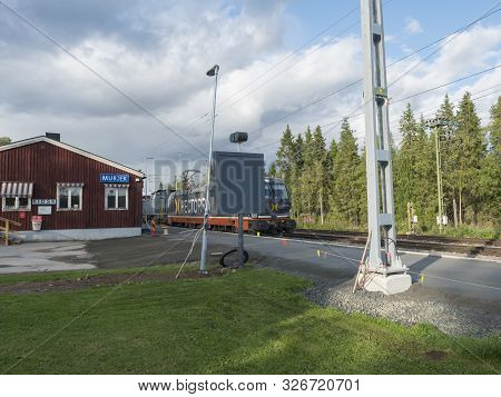 Murjek, Norrbotten, Sweden, Agust 22, 2019: Old Red Bulding Of Train Station At Murjek With Goods Tr