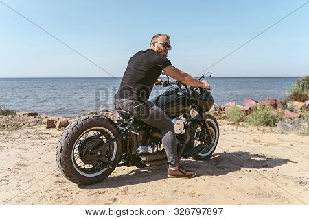 Brutal And Handsome Biker Sitting On Motorcyle