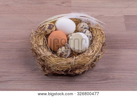Easter Nest Basket Deco With Eggs Feathers On Wooden Background. Beautiful Decoration Easternest Wit