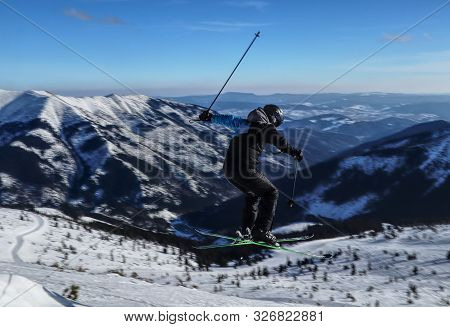 Ski Rider Is In Jump And Looks Like Helicopter. Young Stylish Boy Jumped On Snow Hill And Now He Is 