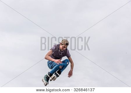 Rollerskater On Halfpipe Flying Through The Air From A Low Angle