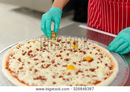 Chefs Hand Preparing Pizza On Kitchen Table Top With Quail Egg,
