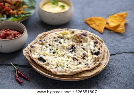Mexican Cuisine On A Gray Stone Background. Homemade Buritto With Cheese, Nachos Chips With Tomato A