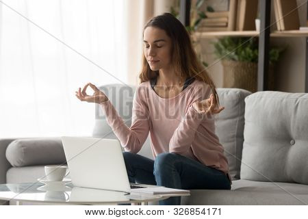 Calm Young Woman Taking Break Doing Yoga Exercise At Home