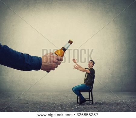 Alcohol Addicted Man, Hands Outstretched, Receiving A Huge Bottle Of Beer From An Unknown Person Han