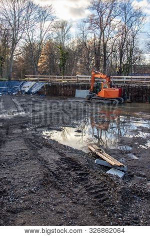 Construction Site. Excavated Excavation For Residential Building With Orange Excavator