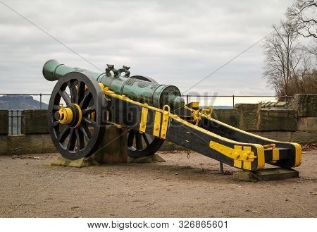 An Antique Cannon On A Lafette In A Castle