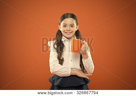 Kid Tested Breakfast. Little Child Having Tea Or Milk For Breakfast On Orange Background. Happy Cute