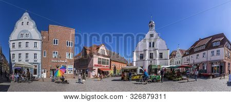 Wolgast, Germany - Aug 13, 2015: People Enjoy Gothic St Petri Church In Wolgast Under Blue Sky With 