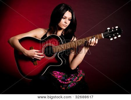 Bella donna Carmen con chitarra su sfondo scuro