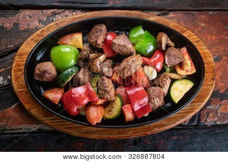 Turkish meat Et Sote isolated on rustic woogen table 