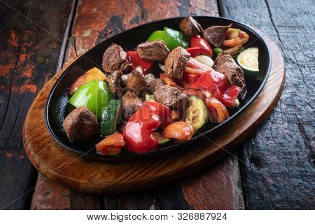 Turkish meat Et Sote isolated on rustic woogen table 