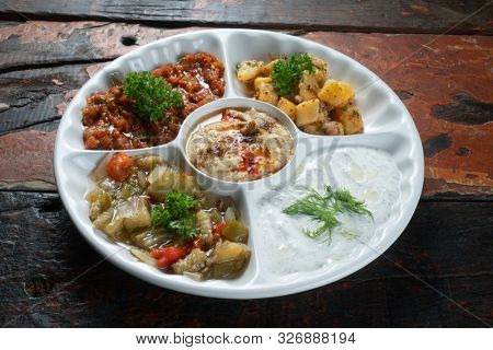 Mix plate arabic food with vegetarian spread starters isolated on rustic wooden background