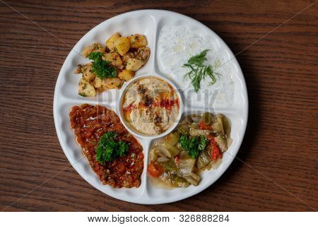 Mix plate arabic food with vegetarian spread starters isolated on wooden background