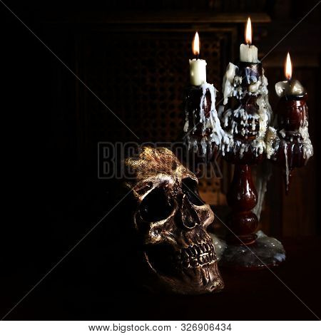 Old Battered Skull Lies With An Antique Wooden Candlestick