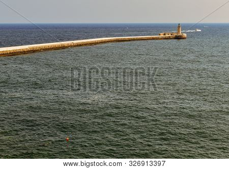 Lighthouse At The End Of The Road, Hanging Out To Sea Near Valletta, Malta.