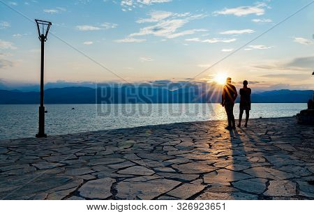 Silhouettes Of Couple Caught By Setting Sun 11standing On Craxy Paving Rock Path Looking Into Sun Ac