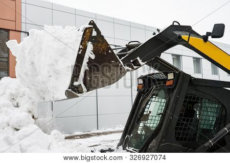 The Fragment Of The Snow-removing Tractor:: Bucket With Snow And Cabin. The Wall Of The Building Is 