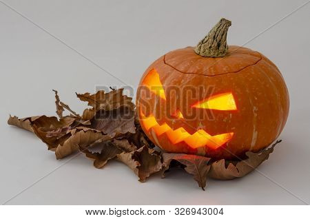 Jacks Head Of A Lantern Carved From Pumpkin For Halloween With Autumn Leaves