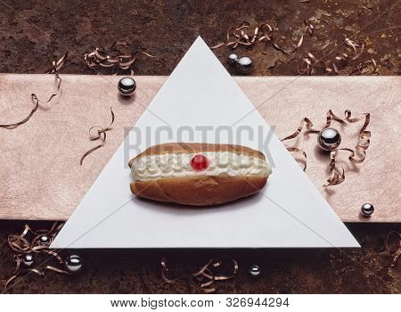 An Aluminum Triangle With A Creamy Doughnut On It, 
Lying On A Sanded Copper Sheet Which Is On Top O