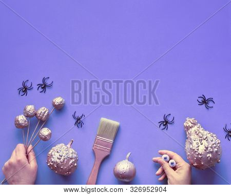 Creative Halloween Flat Lay Background In Purple And Pink, Copy-space. Decorative Pumpkins, Hands, P