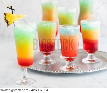 A Tray Of Frosty Colourful Mocktails With One Garnished Mocktail In Front.