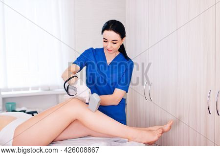 A Black-haired Beautiful Cosmetologist Girl Does Laser Hair Removal Of Her Legs, A Businesswoman In 