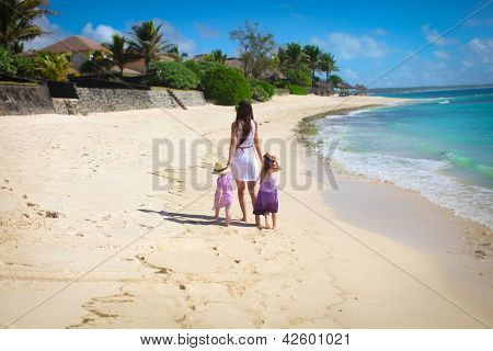 Madre e due bambini in spiaggia giorno pieno di sole