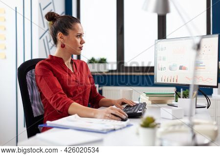 Portrait Of Concentrated Entrepeneur Working And Analyzing Financial Charts, On Computer Monitors Si