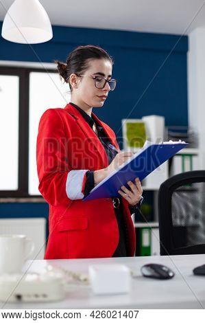 Entrepreneur Standing In Corporate Office Workplace Taking Notes On Clipboard While Doing Financial 