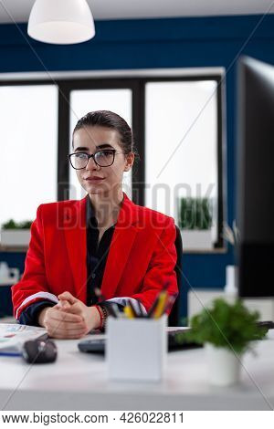 Portraif Of Confident Businesswoman Sitting At Desk In Corporate Office Workplace Building, With Fin