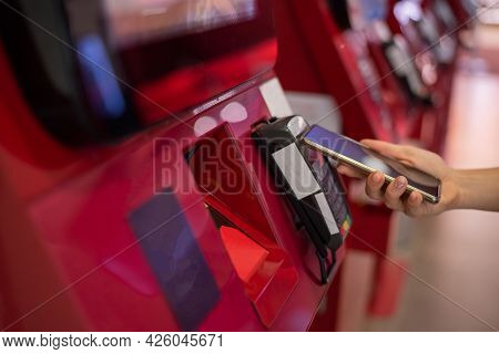 Faceless Caucasian Woman Pays At Selfservice Machine With Contactless Phone Payment.