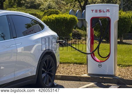 Grantham, Uk - May 30th 2021: Tesla Super Charger Plugged Into A White Tesla Model X.