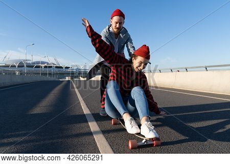 Stylish Man And Woman Longboarding Enjoy Time Together. Young Couple In Romantic Relationship Skatin