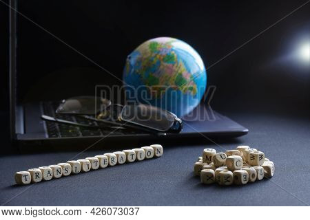 Transliteration Lettering Next To Laptop, Glasses And Globe. Concept Of Work On Translation And Tran