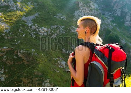 Young Caucasian Woman Smiling And Happy Contemplating A Mountain Landscape During A Hike. Girl Doing
