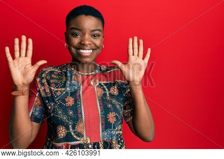 Young african american woman wearing african style showing and pointing up with fingers number ten while smiling confident and happy. 