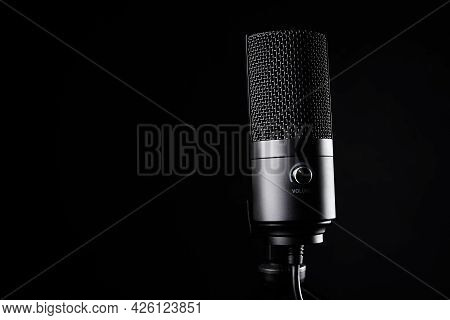 Studio Microphone On Dark Background With Copy Space. Black Professional Condencer Microphone. Podca