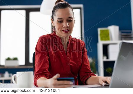 Businesswoman In Corporate Office Workplace Holding Credit Card, Doing Online Payment. Manager Readi