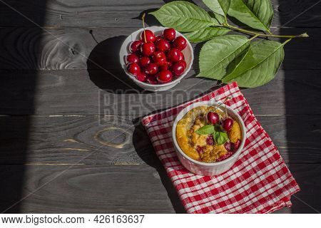 A Portioned Plate With Clafoutis On A Wooden Background On A Bright Sunny Day. Traditional French Pi