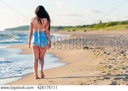 Lonely Young Woman Walking On The Beachsunset Day.beach Woman In Fashion Beachwear Relaxing Walking 