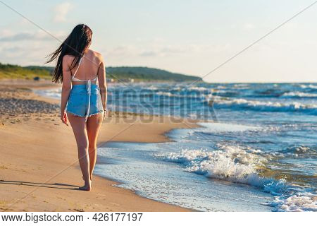 Lonely Young Woman Walking On The Beachsunset Day.beach Woman In Fashion Beachwear Relaxing Walking 