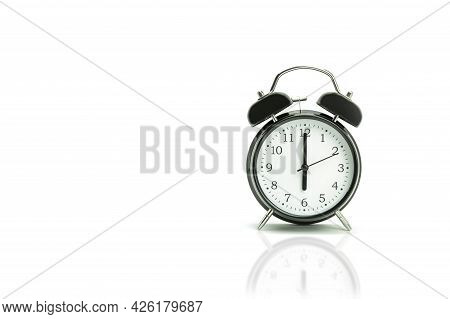 Retro Alarm Clock On A White Background. Black Alarm Clock Showing 6 Hours 00 Minutes On A White Bac
