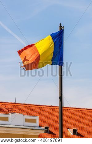 Wind Blowing Romanian Flag On A Blue Clear Sky.