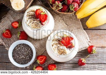 Fresh Yogurt With Strawberries, Banana, Chia Seeds On A Wooden Table, Delicious Dessert For Healthy 
