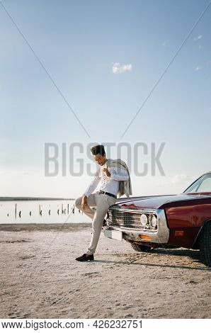 Young Black Man In Nature Posing With A Convertible. Sunset Portrait.