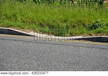 Installation Of Concrete Curbs With Gaps That Let Water Into The Park Into The Ditch, Where It Seeps