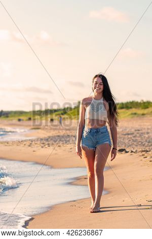 Lonely Young Woman Walking On The Beachsunset Day.beach Woman In Fashion Beachwear Relaxing Walking 
